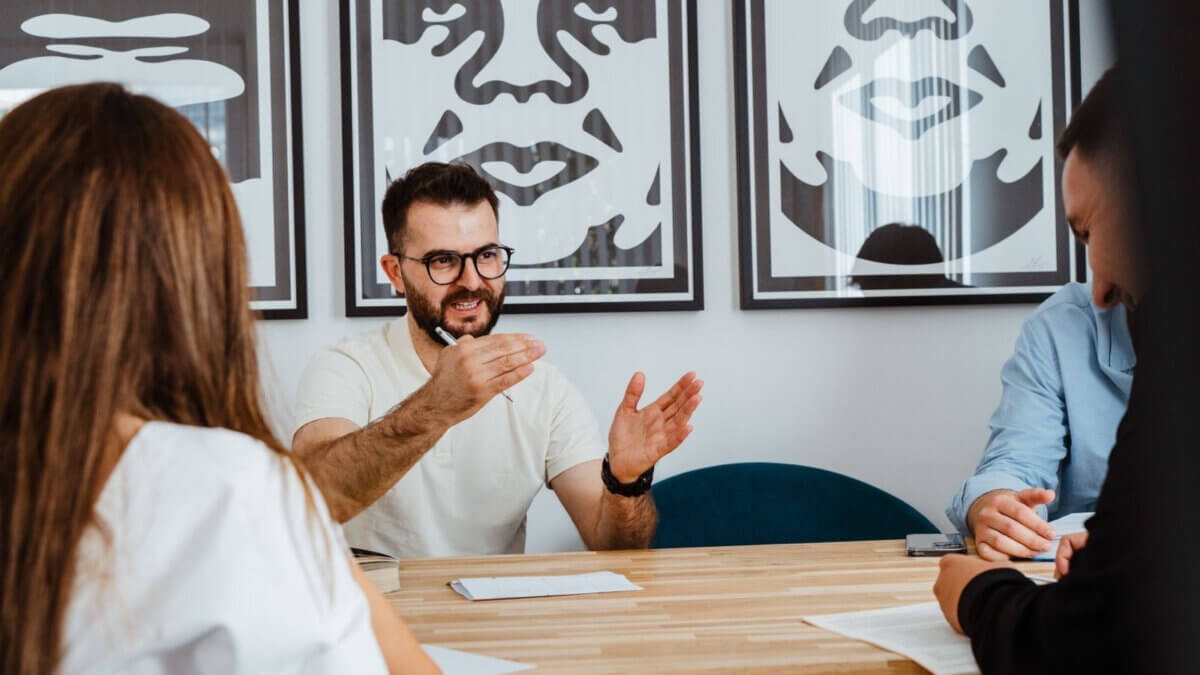 Man leading a business meeting with team members at a modern office table