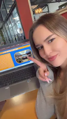 Person pointing at laptop screen displaying website design and content layout