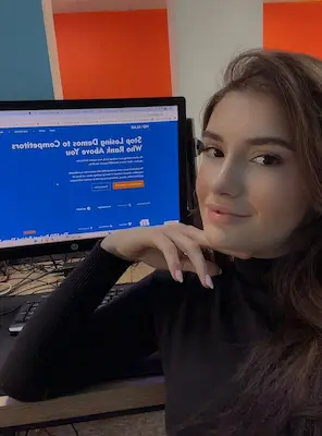 Person sitting at desk with computer displaying website homepage design