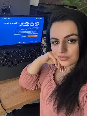 Person sitting at desk with computer displaying website homepage design